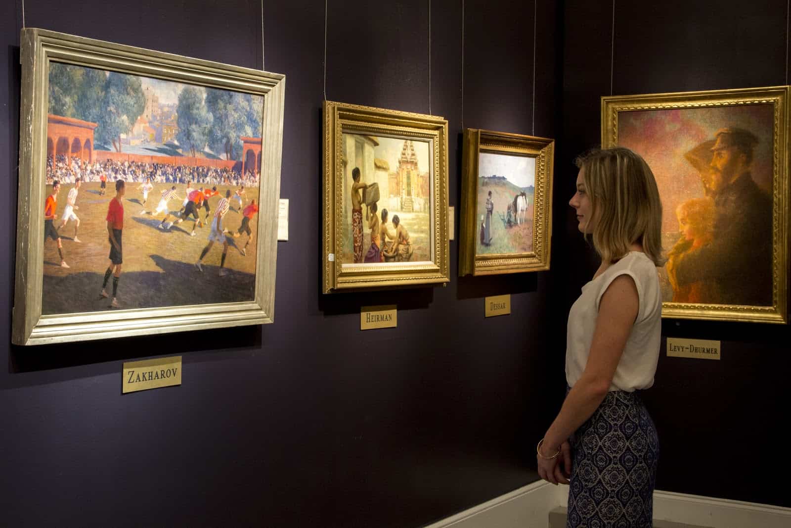 Customer Story: How M.S. Rau Antiques in New Orleans Acquires Affluent Clientele 1 Woman viewing RA painting antiques